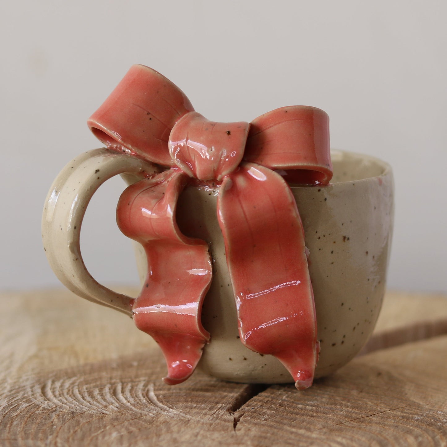 Cremefarvet kop med hank, lyserød sløjfe