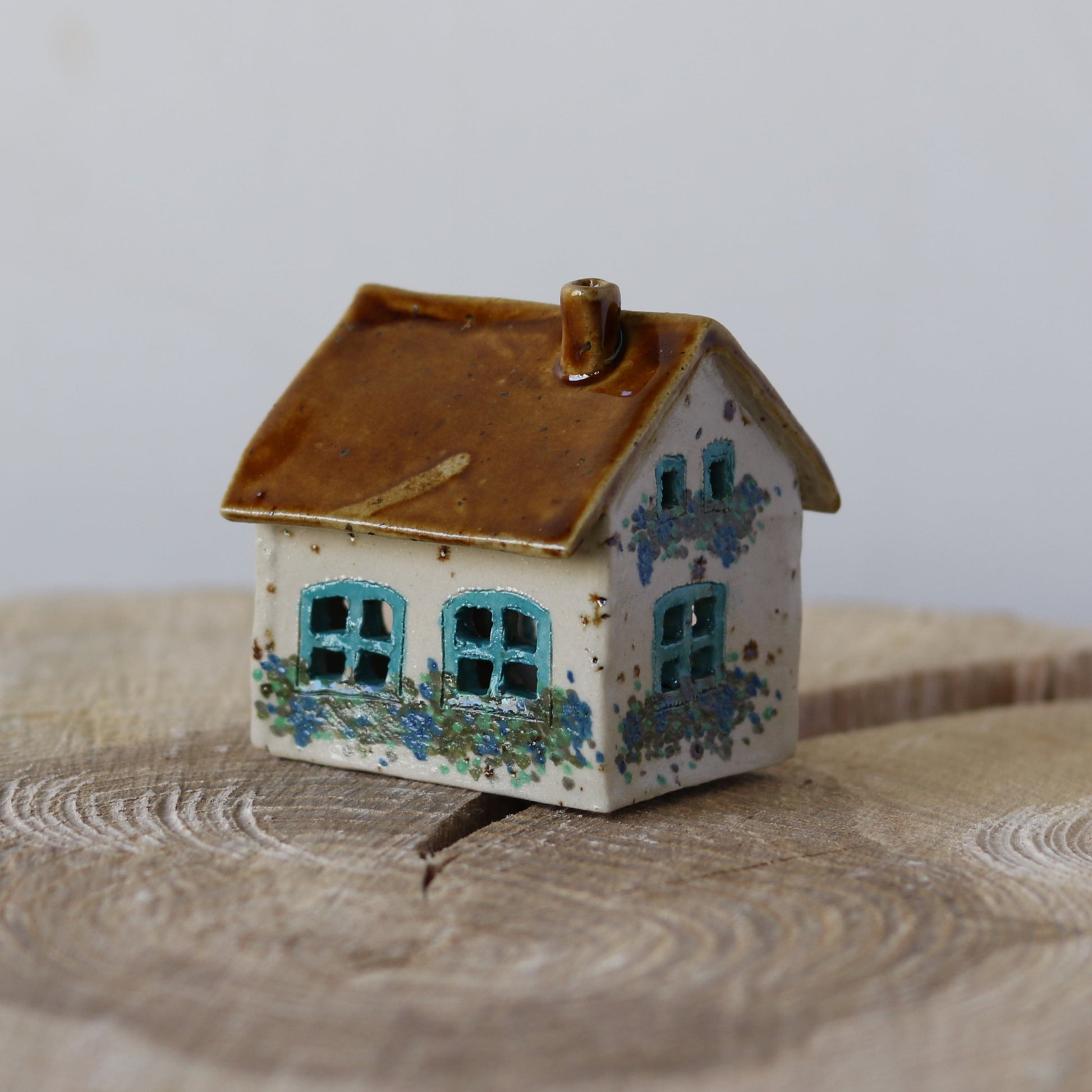 Fe hus, blå dør og blå blomster