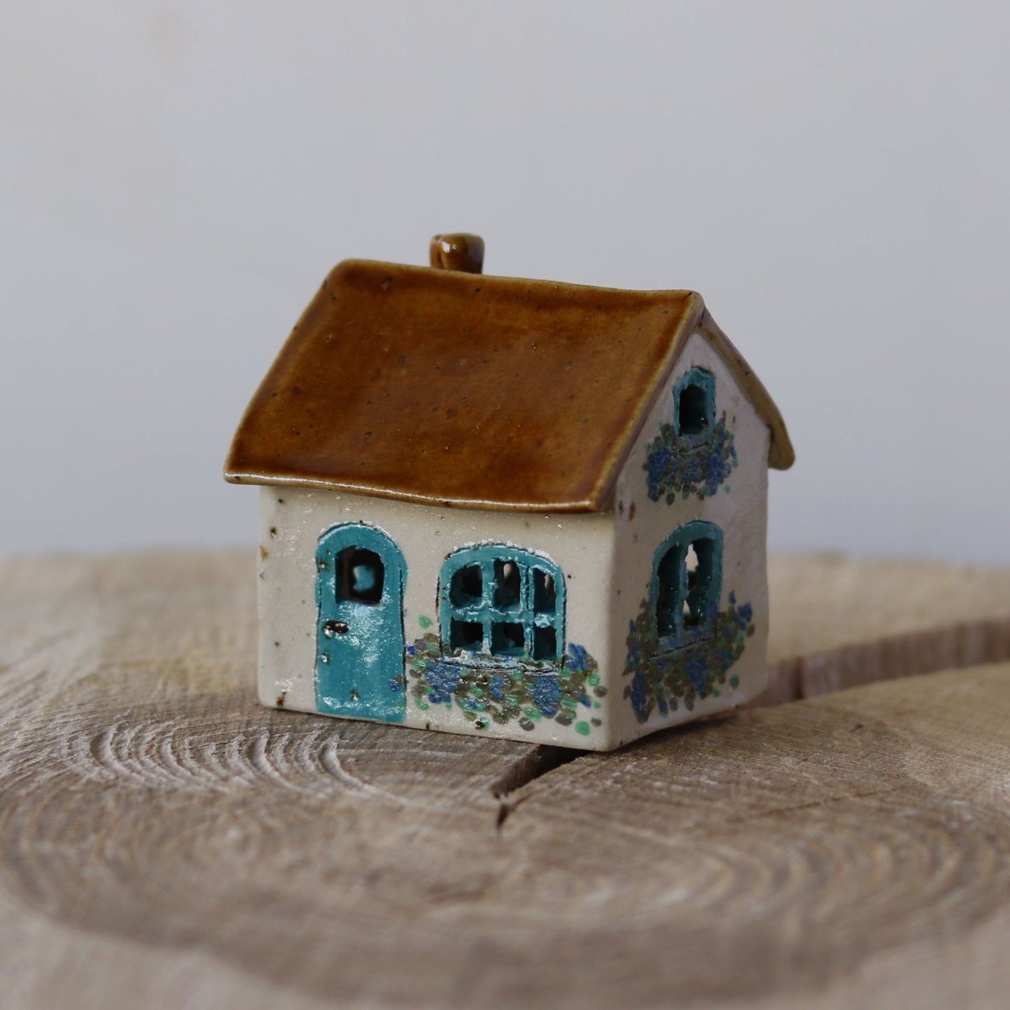 Fe hus, blå dør og blå blomster