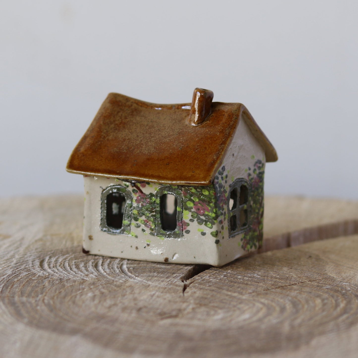 Fe hus, grøn dør og rosa blomster