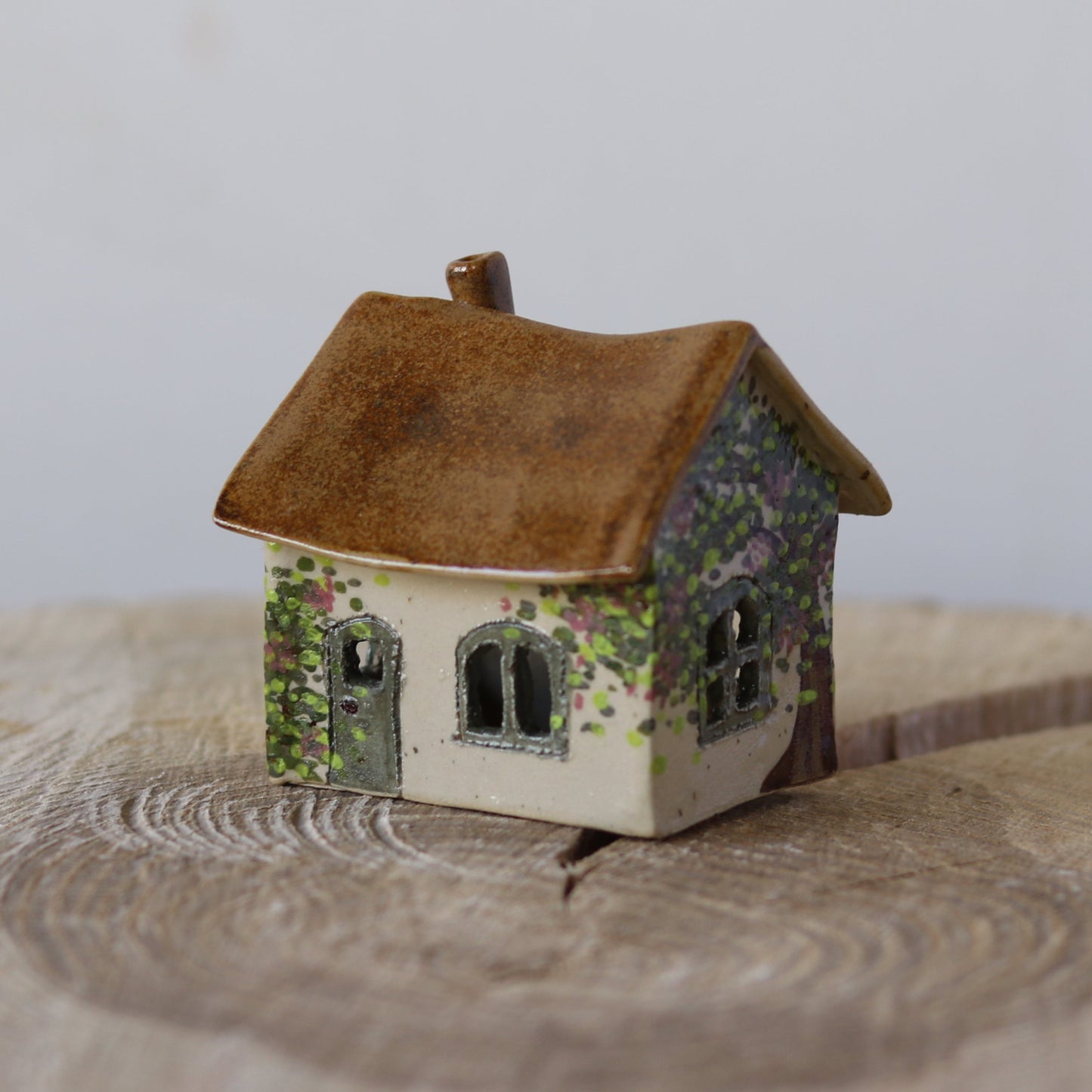 Fe hus, grøn dør og rosa blomster, forside 