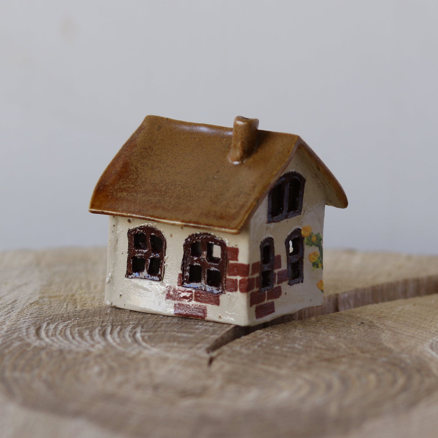 Fe hus, mørkebrun, gule blomster