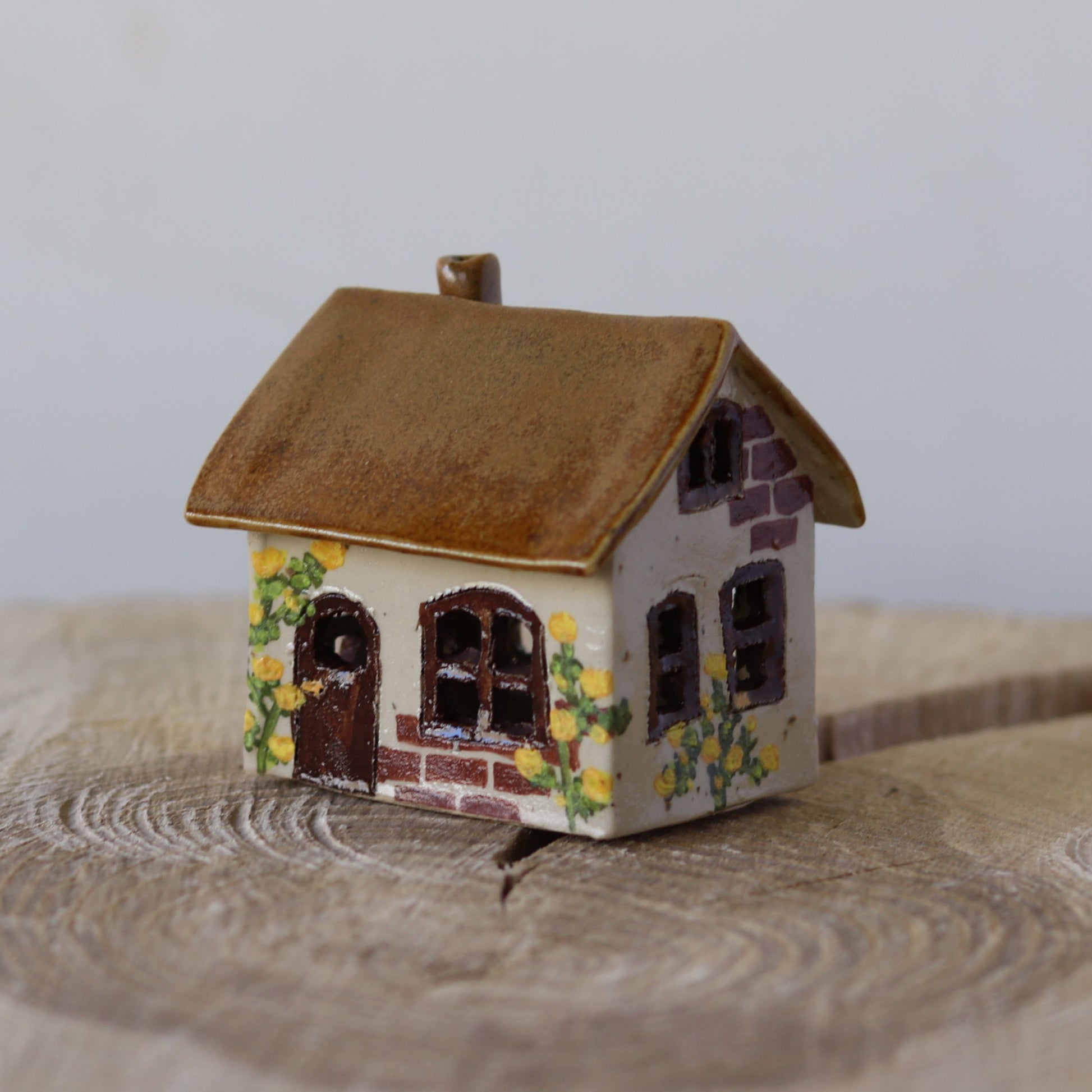 Fe hus, mørkebrun, gule blomster