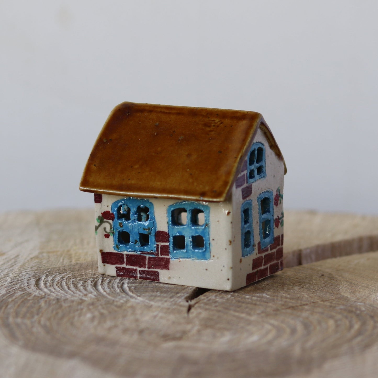 Fe hus, med blå dør og røde blomster