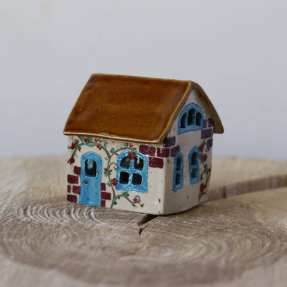 Fe hus, med blå dør og røde blomster