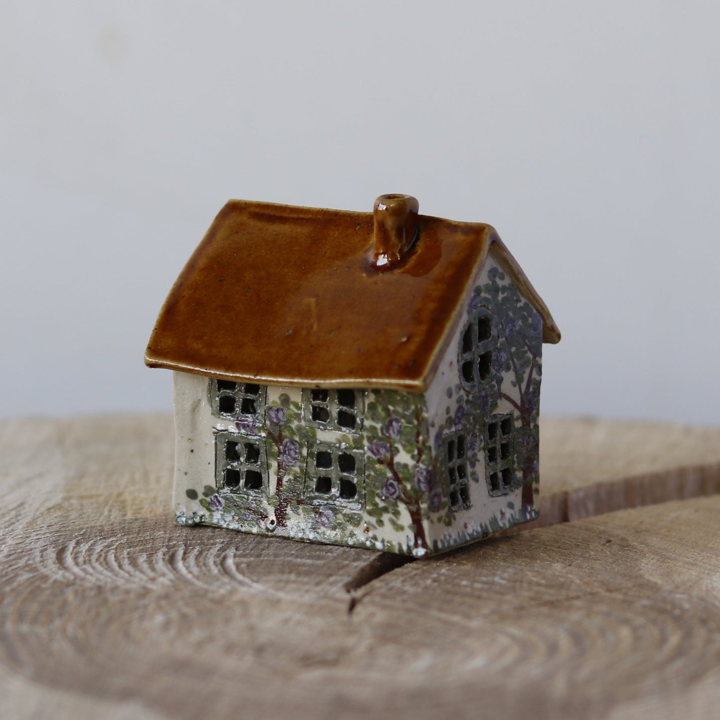 Fe hus, med grøn dør og lilla blomsterbuske