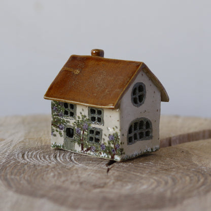 Fe hus, med grøn dør og lilla blomsterbuske