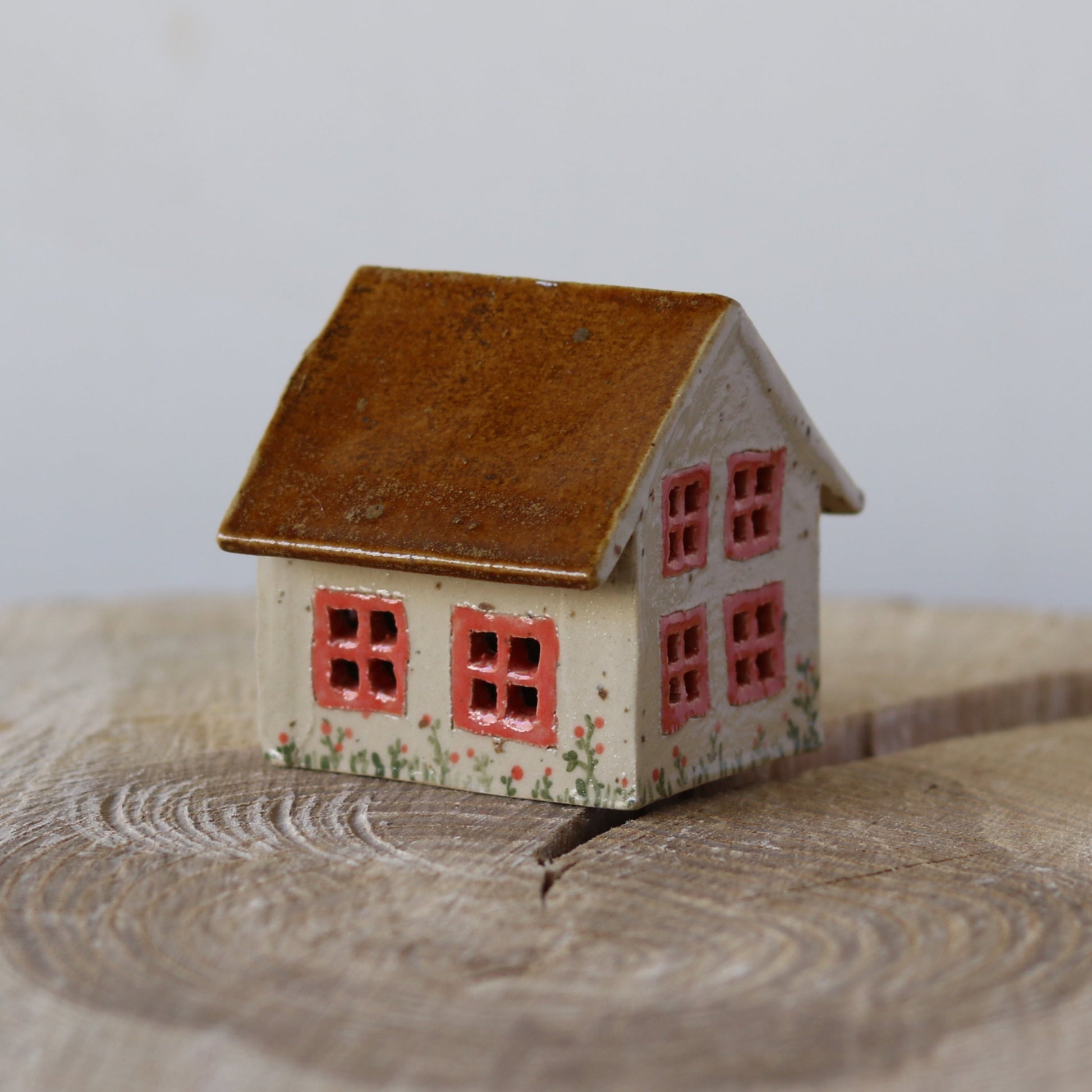 Fe hus, med lyserød dør og lyserøde blomster