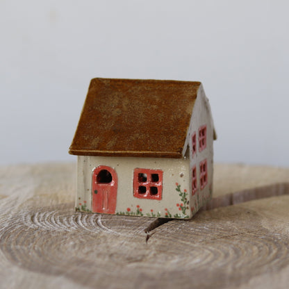 Fe hus, med lyserød dør og lyserøde blomster