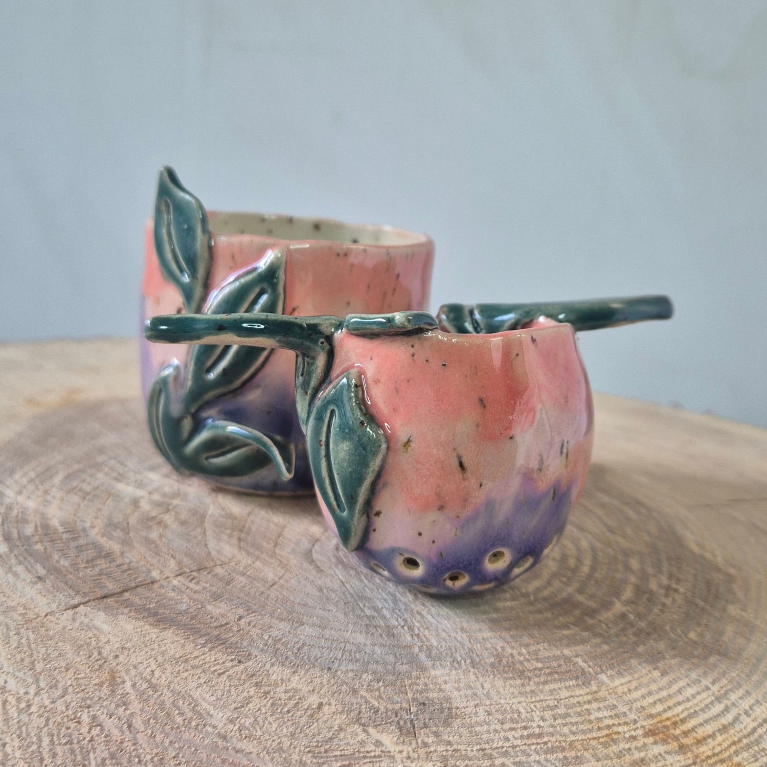 Te se, lyserød og rosa med grønne blade, set fra siden