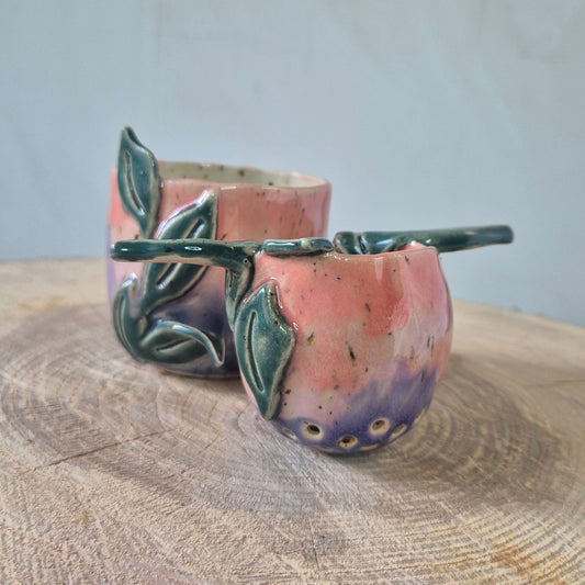 Te se, lyserød og rosa med grønne blade, set fra siden